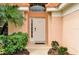 Home's entrance with white door and lush landscaping at 112 Paloma Dr, Davenport, FL 33837