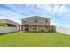 Two story house with covered patio, spacious backyard, and white vinyl fence at 205 Hamlet Rd, Davenport, FL 33837