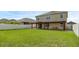 Two story house with covered patio, spacious backyard, and white vinyl fence at 205 Hamlet Rd, Davenport, FL 33837