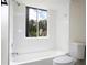 Bright bathroom with a white bathtub, toilet, and tiled walls at 1509 Red Oak Ct, Apopka, FL 32703