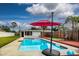 Inviting swimming pool with a red umbrella and wooden deck at 8342 Starr Dr, Orlando, FL 32818