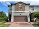 Two-story townhome with a two-car garage and brick driveway at 8502 Arcadia Ln, Davenport, FL 33896