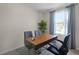 Bright home office features a wood desk, two chairs, and large window at 557 Zinfandel Dr, Holly Hill, FL 32117