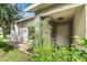 Front entry with white door and lush green plants at 2431 Pewter Ct, Orlando, FL 32837