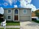 Two story house with a double car garage and manicured lawn at 104 Richmar Ave, Haines City, FL 33844