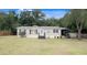 Mobile home with a covered porch and a large grassy yard at 22545 Orange Blossom Ln, Eustis, FL 32736