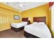 Two twin beds in a well-lit room with yellow walls at 8112 Poinciana Blvd # 1305, Orlando, FL 32821