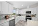 Modern kitchen with white cabinets, stainless steel appliances, and quartz countertops at 6260 Sw 144Th Lane Rd, Ocala, FL 34473