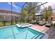 Screened in pool and spa with lounge chairs at 9101 El Caro Ln, Davenport, FL 33896