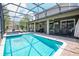 Screened pool and spa with lounge chairs and outdoor TV at 9101 El Caro Ln, Davenport, FL 33896