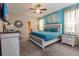 Spacious main bedroom with teal bedding, and an ensuite bathroom at 9101 El Caro Ln, Davenport, FL 33896