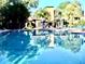 Community pool with lounge chairs and brick fireplace at 3970 Versailles Dr # 3970B, Orlando, FL 32808