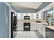 Modern kitchen with white cabinets and black appliances at 636 Koala Ct, Poinciana, FL 34759