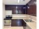 Galley style kitchen with dark wood cabinets and stainless steel appliances at 4100 Dijon Dr # 4100E, Orlando, FL 32808