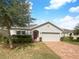 Single-story home with a two-car garage and brick paver driveway at 920 Benjamin Trl, Davenport, FL 33837