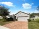 Single-story home with a two-car garage and brick paver driveway at 920 Benjamin Trl, Davenport, FL 33837