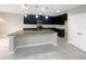 Modern kitchen featuring dark cabinets, granite counters, and an island at 920 Benjamin Trl, Davenport, FL 33837