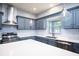 Modern kitchen with gray cabinets, quartz countertops and stainless steel appliances at 1301 Kintla Rd, Apopka, FL 32712