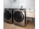 Well-equipped laundry room with two Samsung washers and a utility sink at 1301 Kintla Rd, Apopka, FL 32712