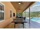 Covered patio with ping pong table and pool view at 2083 Biltmore Pt, Longwood, FL 32779