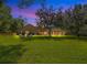 Large backyard with home view at dusk at 2083 Biltmore Pt, Longwood, FL 32779