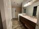 A bathroom with double sinks, a large mirror, and wood cabinets at 185 Winding Cove Ave, Apopka, FL 32703