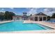 Community pool with lounge chairs and covered seating area at 3174 Feltrim Pl # 104, Kissimmee, FL 34747