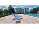Community pool with lounge chairs and adjacent apartment building at 3174 Feltrim Pl # 104, Kissimmee, FL 34747