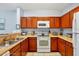 Kitchen with wood cabinets, appliances, and double sink at 3174 Feltrim Pl # 104, Kissimmee, FL 34747