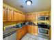 Galley kitchen with wood cabinets and stainless steel appliances at 4099 Dijon Dr # 4099H, Orlando, FL 32808