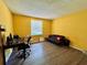 Bright yellow bedroom with window and wood-look flooring at 4099 Dijon Dr # 4099H, Orlando, FL 32808