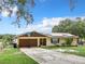 Ranch style home with brown garage door, solar panels and basketball goal at 2405 Boy Scout Rd, Apopka, FL 32703