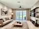 Spacious living room with beige walls, large windows, and access to a patio at 2475 Hastings Blvd, Clermont, FL 34711