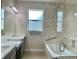 Bathroom with double vanity, quartz countertops, and patterned tile shower surround at 2475 Hastings Blvd, Clermont, FL 34711