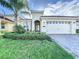 Two-story home with a two-car garage and manicured lawn at 1065 Blackwolf Run Rd, Davenport, FL 33896