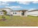 Home's backyard with covered patio and grassy area at 523 Kennedy Dr, Lake Alfred, FL 33850