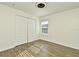 Bright bedroom with wood-look floors and double doors at 5467 Vineland Rd # 6308, Orlando, FL 32811