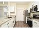 Modern kitchen with white cabinets, granite counters, and stainless steel appliances at 5467 Vineland Rd # 6308, Orlando, FL 32811