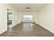 Open living room with wood-look floors and access to other rooms at 5467 Vineland Rd # 6308, Orlando, FL 32811