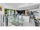 Elegant dining area with glass table and modern chairs, adjacent to kitchen at 241 Riverside Dr # 1901, Daytona Beach, FL 32117