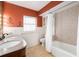 Bathroom with terracotta walls, double vanity, and tub at 1330 Webster St, Orlando, FL 32804