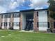 Brick apartment building with a grassy area and multiple AC units at 5317 Curry Ford Rd # O205, Orlando, FL 32812