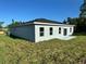 Rear view of a single-story home with gray exterior and sliding glass door at 13053 Sw 36Th Ct, Ocala, FL 34473