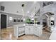Modern kitchen with white cabinets, a large island, and a stone accent wall at 1451 Lyndale Blvd, Winter Park, FL 32789