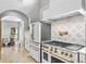Modern kitchen with white cabinets, gold accents, and geometric backsplash at 1451 Lyndale Blvd, Winter Park, FL 32789