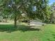 White detached garage with large oak tree in yard at 423 E 9Th St, Frostproof, FL 33843