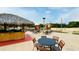 Seating area with tables and umbrellas near pool at 2214 Calabria Ave, Davenport, FL 33897
