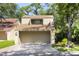 Tan two-story townhome with a garage and American flags at 201 Weeping Elm Ln, Longwood, FL 32779