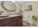 Guest bathroom with dark wood cabinets and decorative accents at 201 Weeping Elm Ln, Longwood, FL 32779