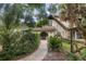 Front entry with a walkway, lush landscaping, and a rustic fence at 5006 Cub Lake Dr, Apopka, FL 32703